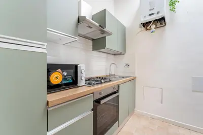 a kitchen with a stove and a microwave at Nora's Home, Charmy Apt in the Heart of Trastevere in Rome