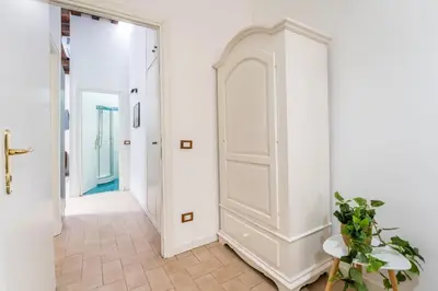 a hallway with a white door and a tile floor at Nora's Home, Charmy Apt in the Heart of Trastevere in Rome