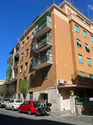 a red car parked in front of a building at Casa Alessi in Rome elegant, spacious and comfortable apartment in Rome