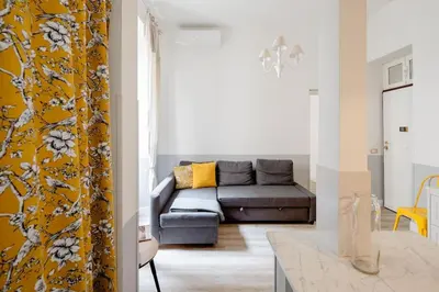 a living room with a couch and a yellow wall at A casa di Clara in Rome