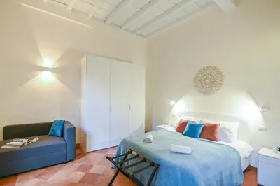a bedroom with a bed and a blue couch at Suite 109 in Rome