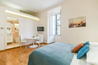 a bedroom with a bed and a table with chairs at Suite 109 in Rome