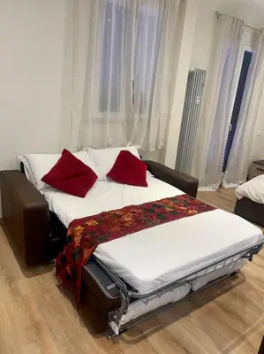 a bed in a room with red pillows on it at Attico Loft con terrazza Vía dei Coronari - Roma in Rome