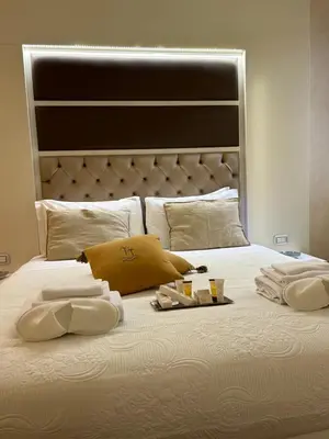 a white bed with two towels and two drinks on it at Piazza Venezia Luxury Suite in Rome