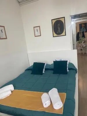 a bedroom with a green bed with two pillows at Casa di Mochi in Rome
