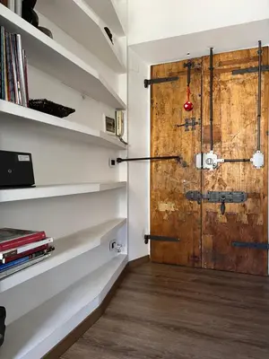 a room with a wooden door and shelves at Colosseo Suite in Rome