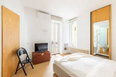 a bedroom with a bed and a television and a chair at iFlat The Carpet Apartment in Rome
