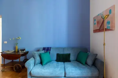 a blue couch with green pillows in a living room at iFlat The gem of the center in Rome
