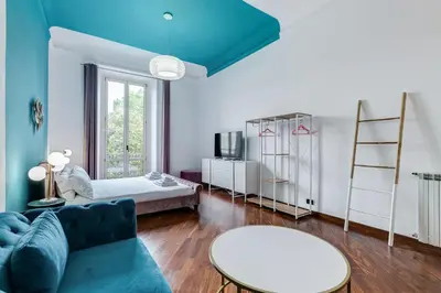 a living room with a blue couch and a table at BMGA l Luxury 3Bdr Apt with Stunning View in City Center in Rome