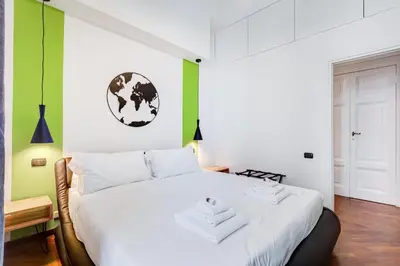 a white bed in a room with green walls at BMGA l Luxury 3Bdr Apt with Stunning View in City Center in Rome