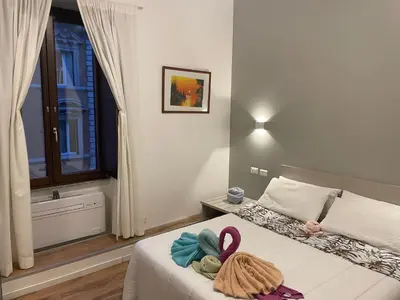 a bedroom with two beds with towels on them at Vatican Suite 