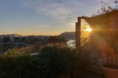 a view of the sunset from a balcony of a building at Beautiful Loft in Ponte Milvio with terrace in Rome