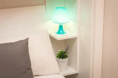 a blue lamp sitting on a shelf next to a bed at Trastevere Home by Rental in Rome in Rome