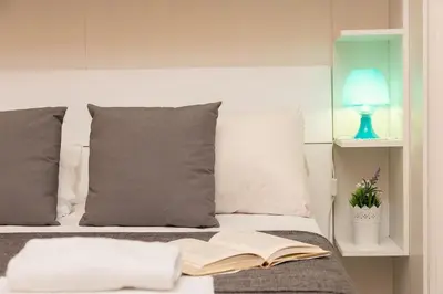 an open book laying on a bed with a lamp at Trastevere Home by Rental in Rome in Rome