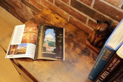 a book sitting on a table next to a statue at Casina degli Eroi in Rome