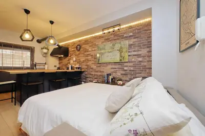 a bedroom with a white bed and a brick wall at Casina degli Eroi in Rome