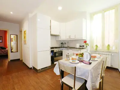 a kitchen with a table with chairs and a white kitchen at The Artist House in Rome