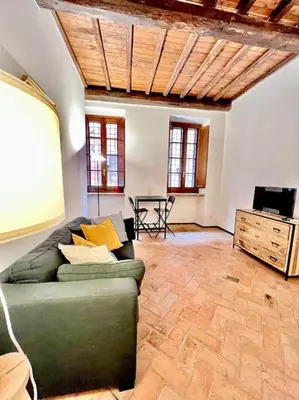 a living room with a green couch and a television at Appartamento nel cuore di Roma in Rome