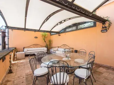 a patio with a table and chairs in a room at Panoramic Terrace Trastevere in Rome