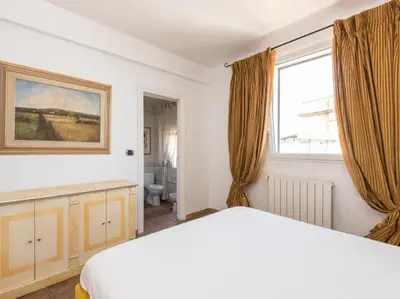 a bedroom with a white bed and a window at Panoramic Terrace Trastevere in Rome