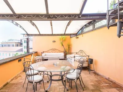 a patio with a table and chairs on a balcony at Panoramic Terrace Trastevere in Rome