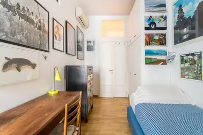 a bedroom with a bed and a desk and pictures on the wall at Maison Regola, Styilish Apt in Campo De Fiori in Rome