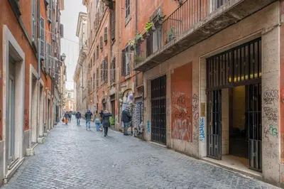 a group of people walking down a street with buildings at Maison Regola, Styilish Apt in Campo De Fiori in Rome