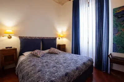 a bedroom with a bed and a large window at Il giardino di Bobo in Rome