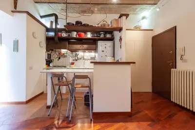 a kitchen with a counter and stools in a room at Il giardino di Bobo in Rome