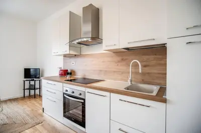 a kitchen with white cabinets and a sink at Naos Suite close Popolo Square in Rome