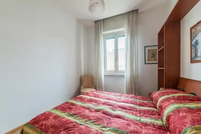 a bedroom with a bed with a red comforter and a window at GuestHost - Sunny Apartment Piramide in Rome
