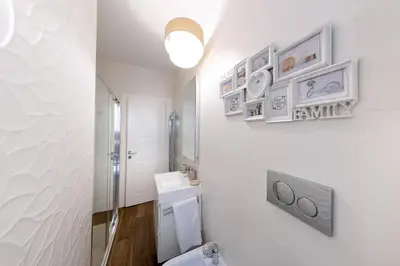 a bathroom with a toilet and some pictures on the wall at Barcaccia Exclusive apartment in Rome
