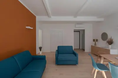 a living room with a blue couch and chairs at Noah Charme in Rome