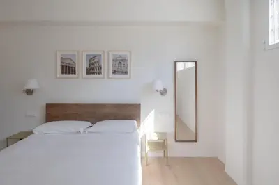 a white bedroom with a bed and a mirror at Noah Charme in Rome