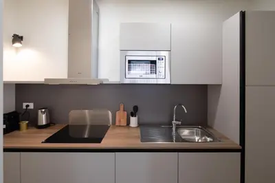 a white kitchen with a sink and a microwave at Noah Charme in Rome