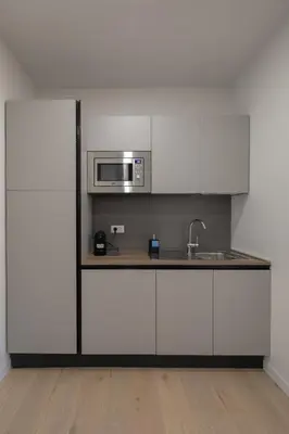 a kitchen with white cabinets and a microwave at Matilda Charme in Rome