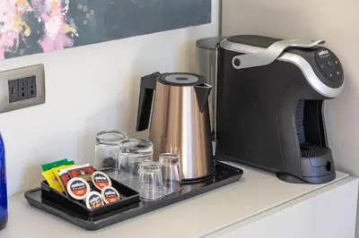 a coffee maker on a black tray on a kitchen counter at Elegantia Luxury Rooms in Rome