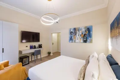 a bedroom with a white bed and a couch at Elegantia Luxury Rooms in Rome