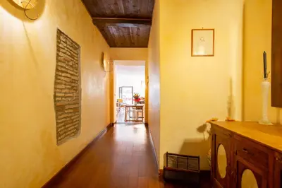 a hallway with yellow walls and a wooden floor at Appartamento via di San Martino ai Monti in Rome