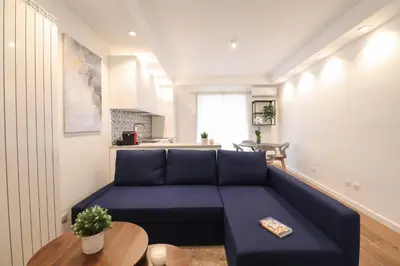 a living room with a blue couch and a table at Ziani 5 Rome Vatican Apartment in Rome