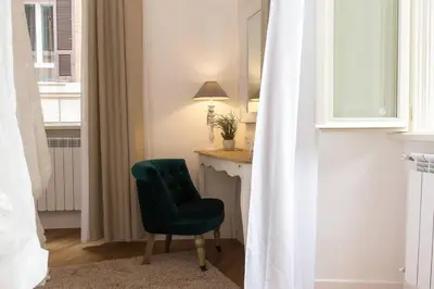 a green chair sitting next to a desk in a room at Navona Atmosphere A few meters from Piazza Navona !! in Rome