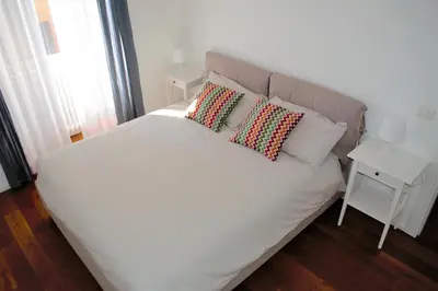 a white bed with two pillows on top of it at Eternal City Apartment in Rome