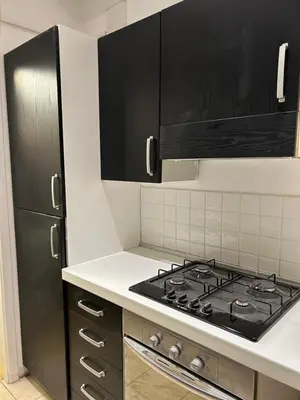 a kitchen with a stove and black cabinets at Raffaello's Place in Rome