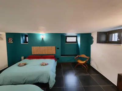 a bedroom with two beds and a blue wall at Il quattro e l'otto in Rome