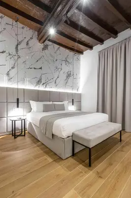 a bedroom with a large bed and a marble wall at Home at Rome Luxury Navona Guesthouse in Rome