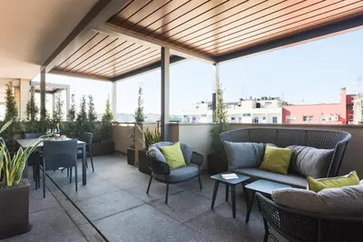 a patio with a couch and a table and chairs at Idyllia - Lumina rooftop penthouse in Trastevere in Rome