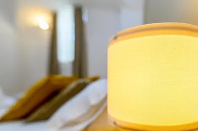 a yellow candle sitting on top of a bed at Cozy & Central with Private Entrance by NDP rent in Rome