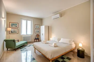a bedroom with a bed and a green chair at Borgo Vittorio 2 bdr 2 bath St Peter's in Rome