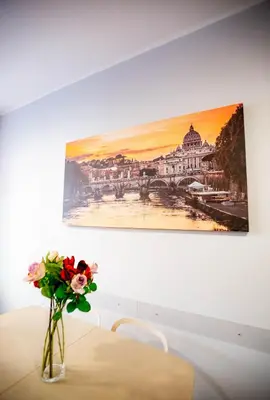 a vase of flowers sitting on a table under a painting at DOMUS PETRI- CASA A S. PIETRO in Rome