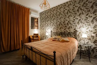 a bedroom with a bed with a patterned wall at DOMUS PETRI- CASA A S. PIETRO in Rome